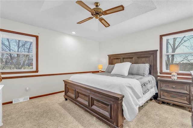 carpeted bedroom featuring ceiling fan and a textured ceiling