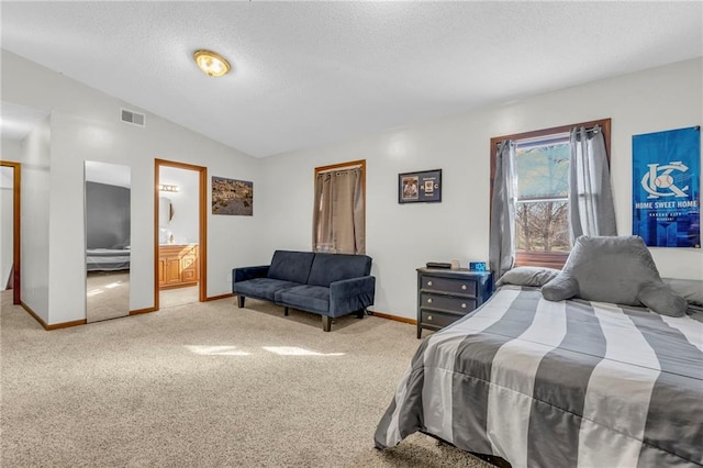 bedroom with carpet flooring, ensuite bath, and lofted ceiling