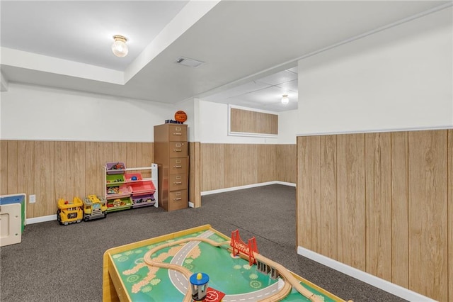 game room featuring dark carpet and wooden walls