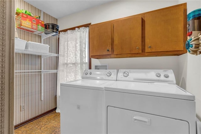 laundry room featuring washer and dryer and cabinets