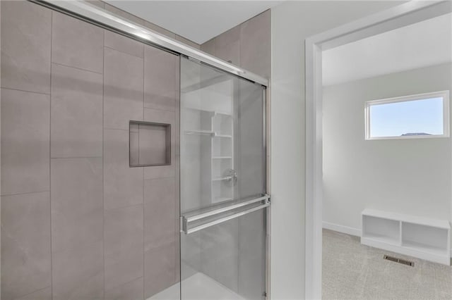 bathroom featuring a shower with shower door