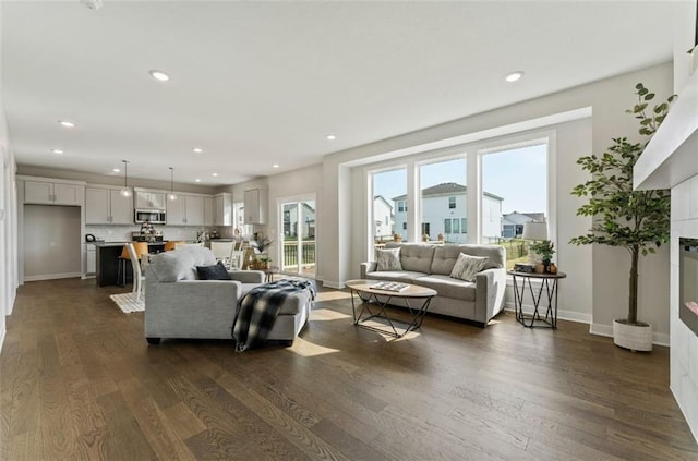 17744 Houston St, Gardner, KS 66030 - living area featuring dark wood-style floors, recessed lighting, baseboards, and a glass covered fireplace