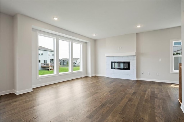 17744 Houston St, Gardner, KS 66030 - unfurnished living room with dark wood-style flooring, a tile fireplace, baseboards, and recessed lighting