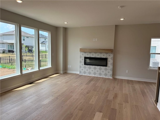 17744 Houston St, Gardner, KS 66030 - unfurnished living room featuring light wood finished floors, a fireplace, and recessed lighting
