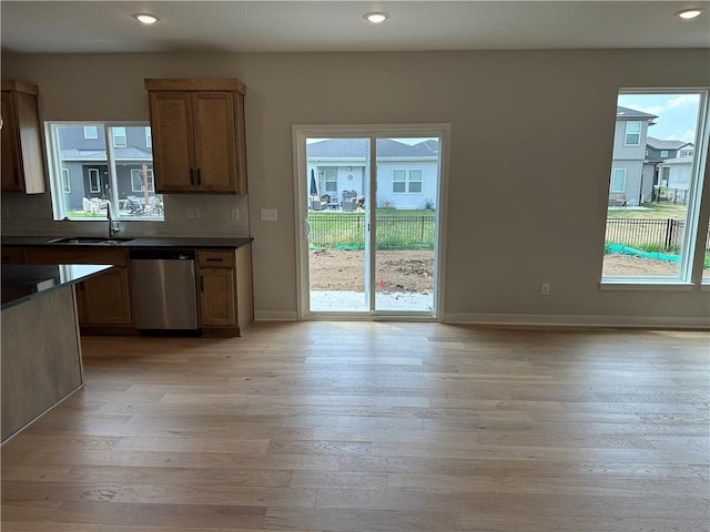 17744 Houston St, Gardner, KS 66030 - kitchen with stainless steel dishwasher, dark countertops, light wood-style flooring, recessed lighting, and decorative backsplash