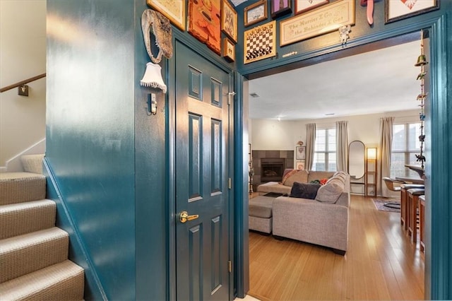 staircase featuring hardwood / wood-style flooring and a tiled fireplace