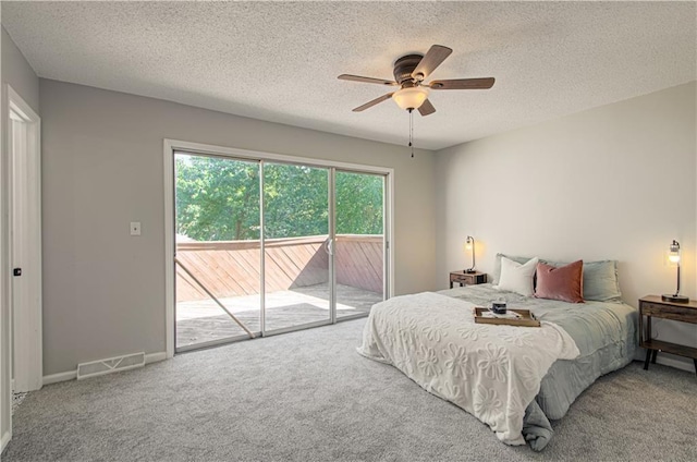 bedroom featuring ceiling fan, access to exterior, carpet floors, and a textured ceiling