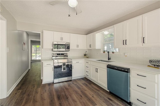 kitchen with dark wood-type flooring, white cabinetry, sink, and stainless steel appliances