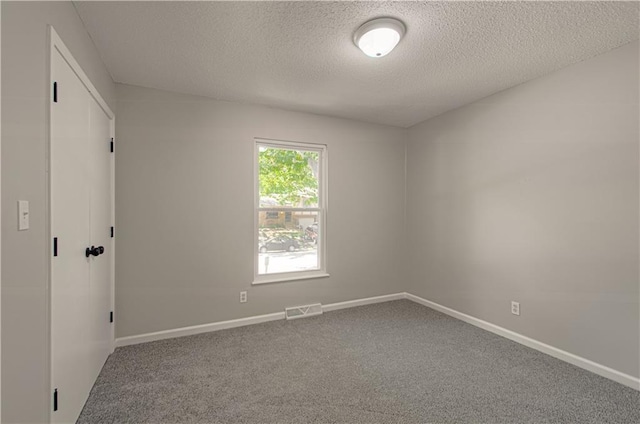 unfurnished room featuring carpet flooring and a textured ceiling