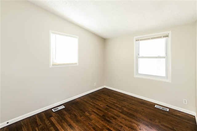 spare room featuring wood-type flooring and lofted ceiling