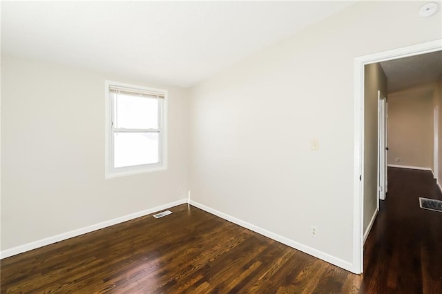 unfurnished room with dark wood-type flooring