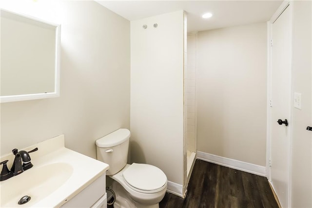 bathroom with hardwood / wood-style flooring, vanity, toilet, and walk in shower