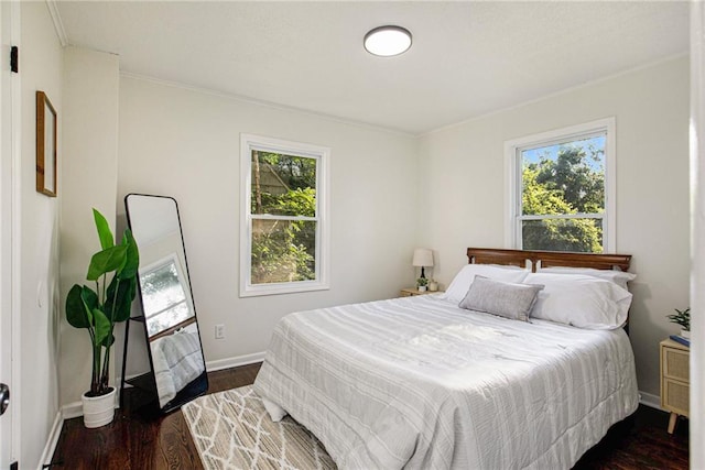 bedroom with crown molding, multiple windows, and dark wood-type flooring