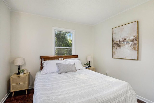 bedroom with dark hardwood / wood-style flooring and ornamental molding