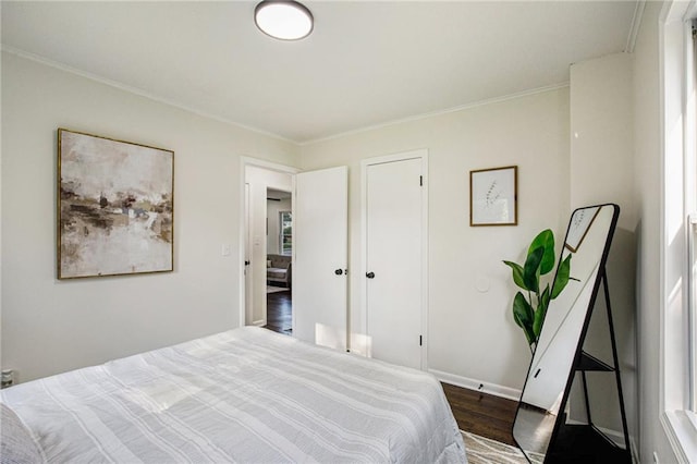 bedroom with crown molding and dark hardwood / wood-style floors