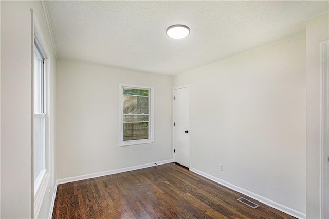 unfurnished room featuring a textured ceiling, crown molding, and dark wood-type flooring