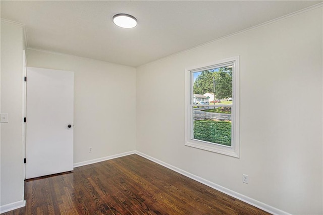 empty room featuring dark hardwood / wood-style flooring and ornamental molding