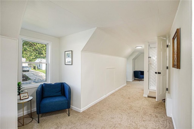 corridor with light carpet and vaulted ceiling