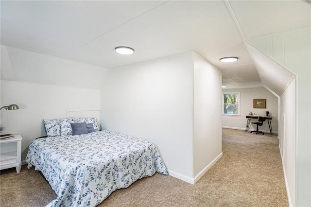 bedroom featuring light colored carpet and lofted ceiling