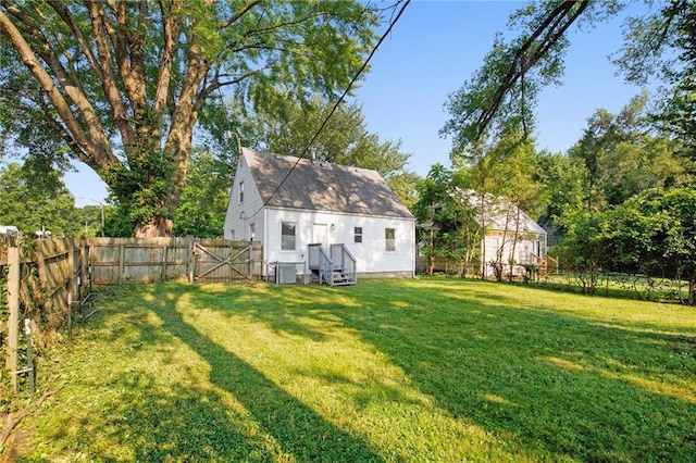 rear view of house featuring a yard and central AC