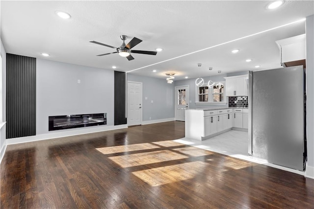 unfurnished living room featuring ceiling fan and light wood-type flooring