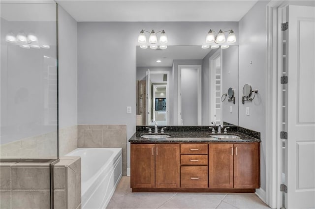 bathroom featuring tile patterned flooring, vanity, and a tub to relax in