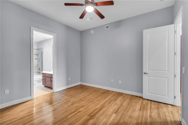 unfurnished bedroom with ceiling fan, light wood-type flooring, and connected bathroom