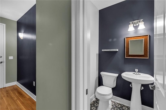 bathroom with hardwood / wood-style flooring, toilet, and sink