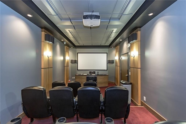 carpeted cinema room with a tray ceiling and ornamental molding