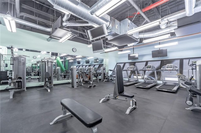 exercise room featuring a towering ceiling