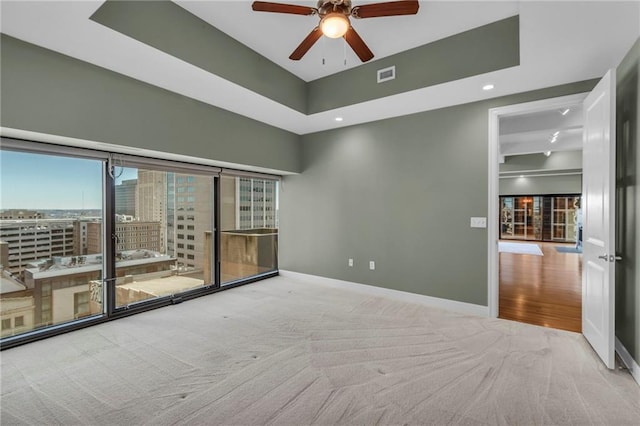 spare room featuring ceiling fan and light colored carpet