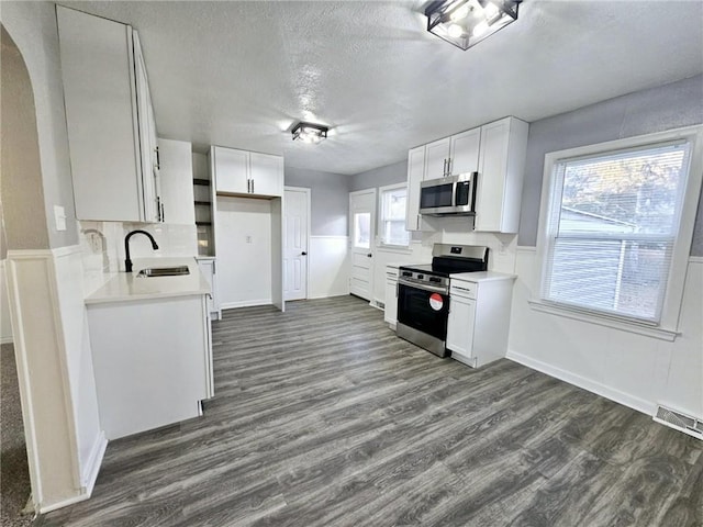 kitchen with sink, white cabinets, a healthy amount of sunlight, and appliances with stainless steel finishes