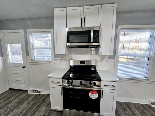 kitchen featuring stainless steel appliances, white cabinetry, and plenty of natural light