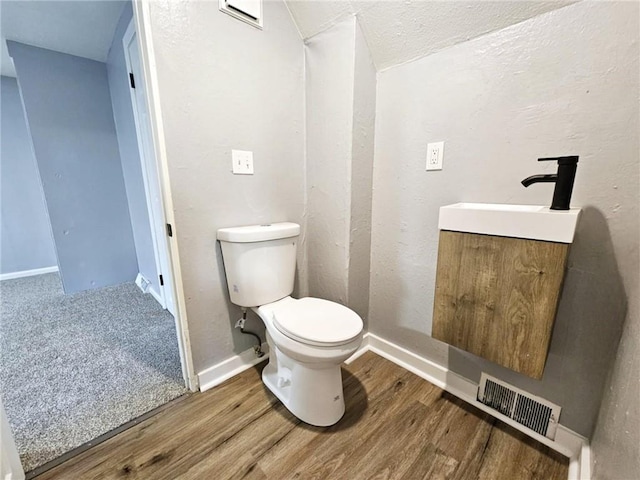 bathroom featuring vanity, hardwood / wood-style flooring, and toilet