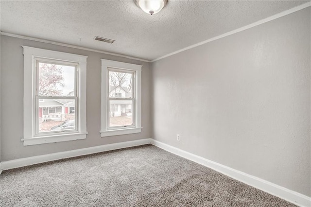 carpeted empty room featuring ornamental molding and a textured ceiling