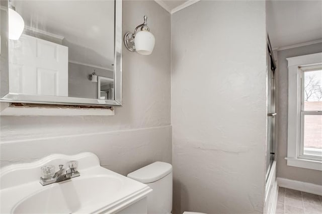 full bathroom featuring bath / shower combo with glass door, vanity, ornamental molding, and toilet