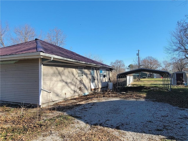 view of home's exterior with a carport and a storage shed