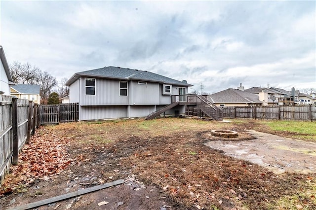 rear view of property featuring a deck and an outdoor fire pit