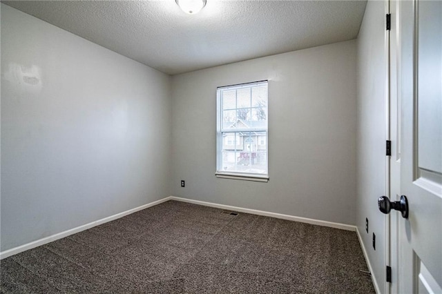 carpeted spare room with a textured ceiling