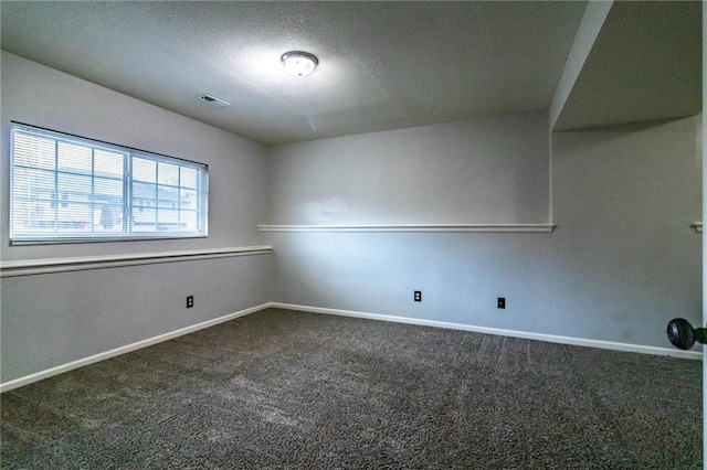 carpeted empty room featuring a textured ceiling