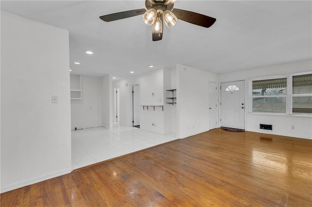 unfurnished living room featuring ceiling fan and light hardwood / wood-style floors