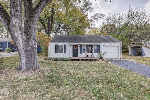 ranch-style home featuring a porch, a garage, and a front yard