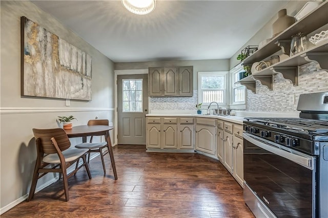 kitchen featuring decorative backsplash, dark hardwood / wood-style flooring, plenty of natural light, and stainless steel gas range oven