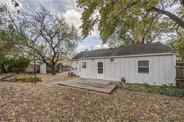 rear view of house featuring a wooden deck, central AC unit, and a storage shed