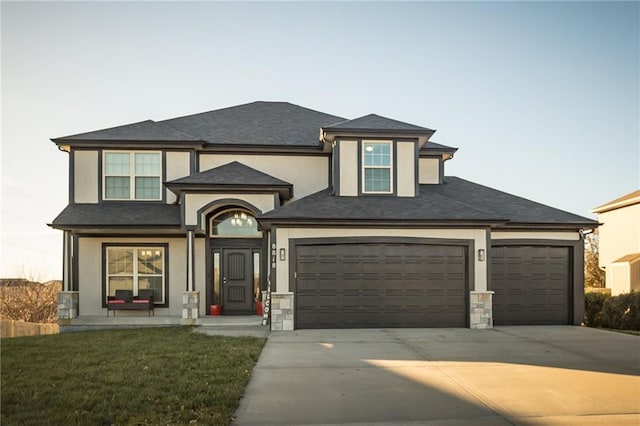 prairie-style home with a front yard and a garage