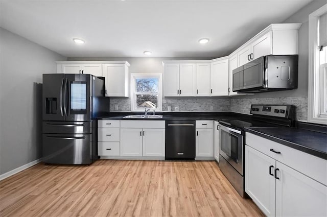 kitchen with sink, white cabinets, stainless steel appliances, and light wood-type flooring