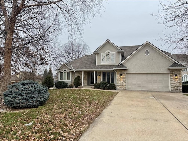 traditional-style home featuring stucco siding, a front yard, a garage, stone siding, and driveway