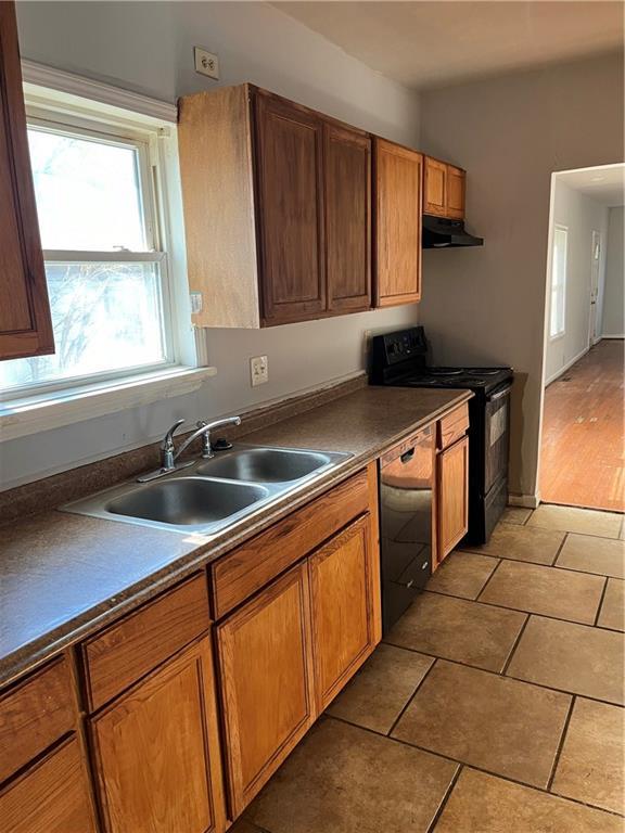 kitchen featuring black appliances, sink, and light hardwood / wood-style flooring