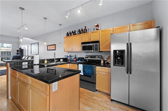 kitchen featuring stainless steel appliances, sink, pendant lighting, light brown cabinets, and light hardwood / wood-style flooring