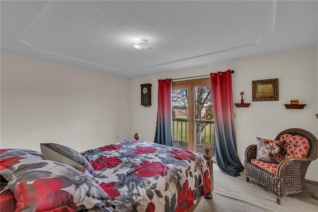 bedroom featuring access to outside, light colored carpet, and a textured ceiling